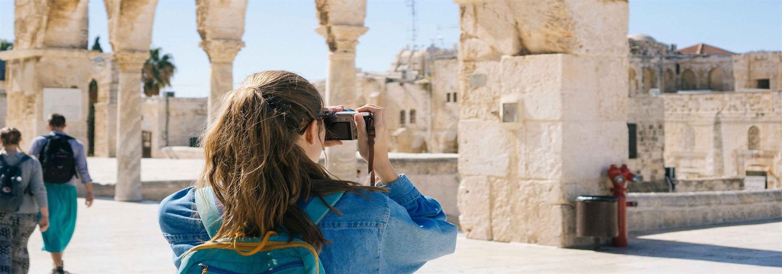 A teen photographing historic architecture in Jerusalem