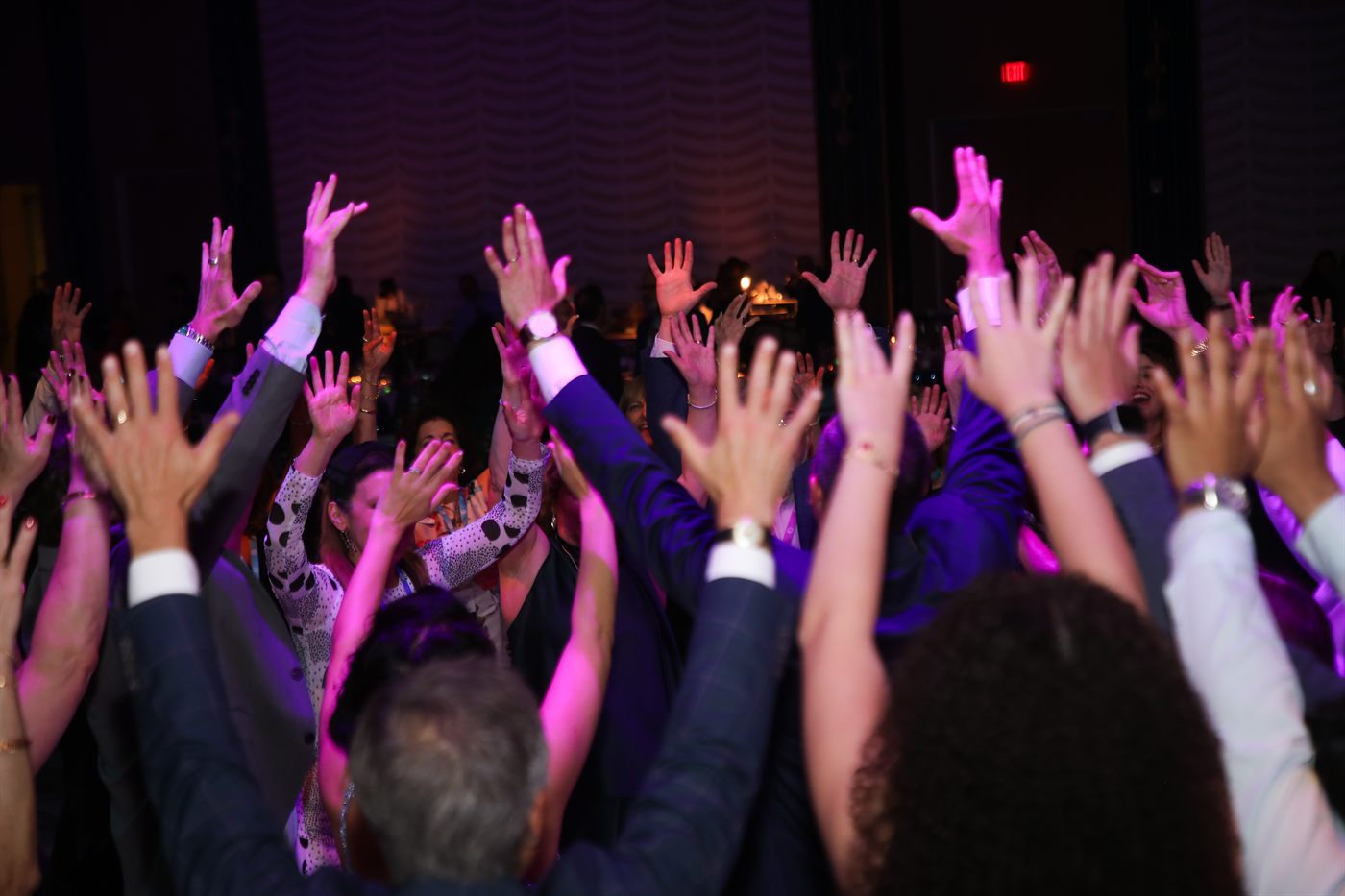 Community members with hands raised at FED360: All In